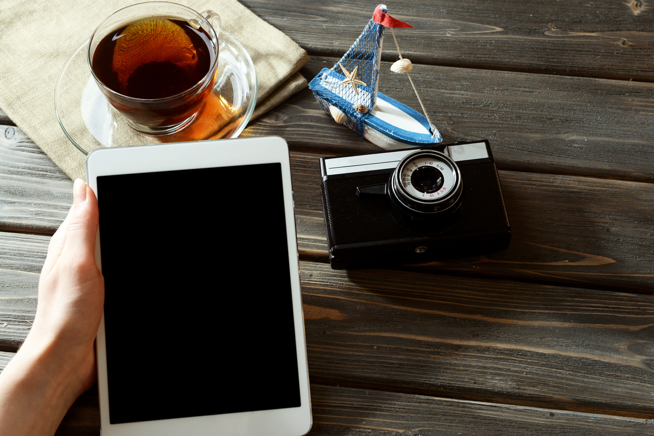 Man Holding Tablet with Camera and Cup of Tea